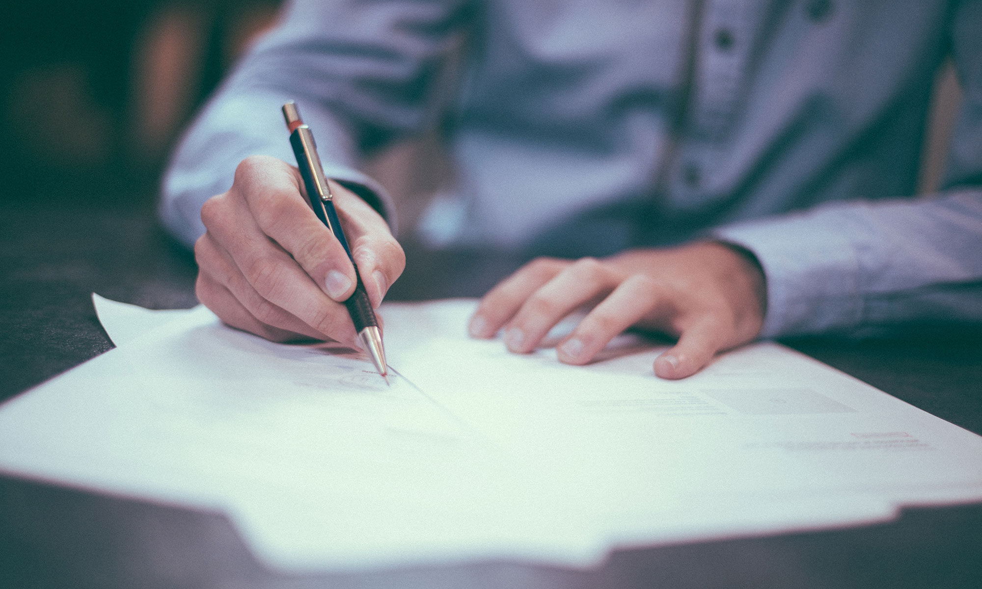 Persona firmando un documento de cesión de derechos hereditarios